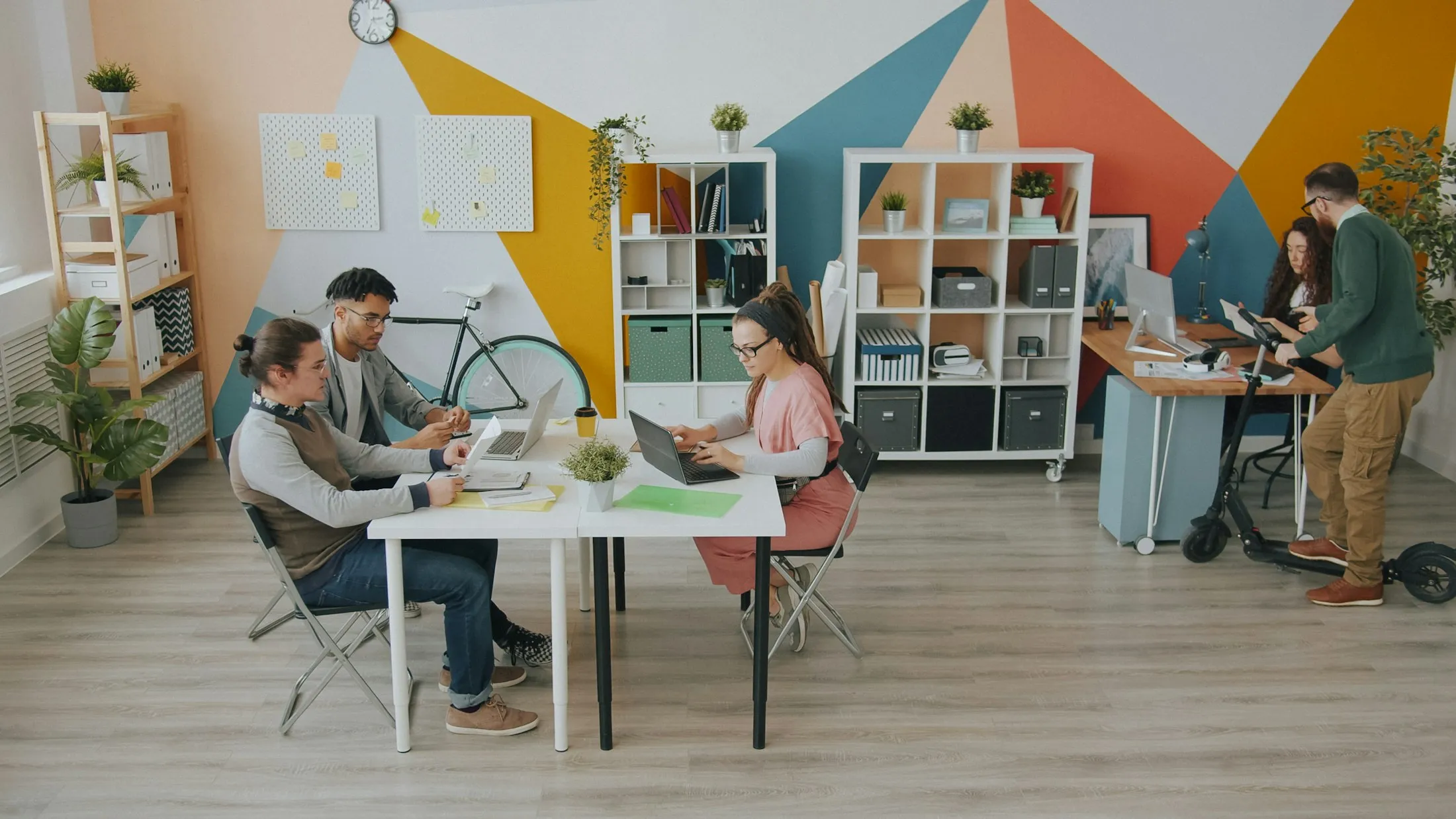 Personas trabajando en una oficina abierta y colorida