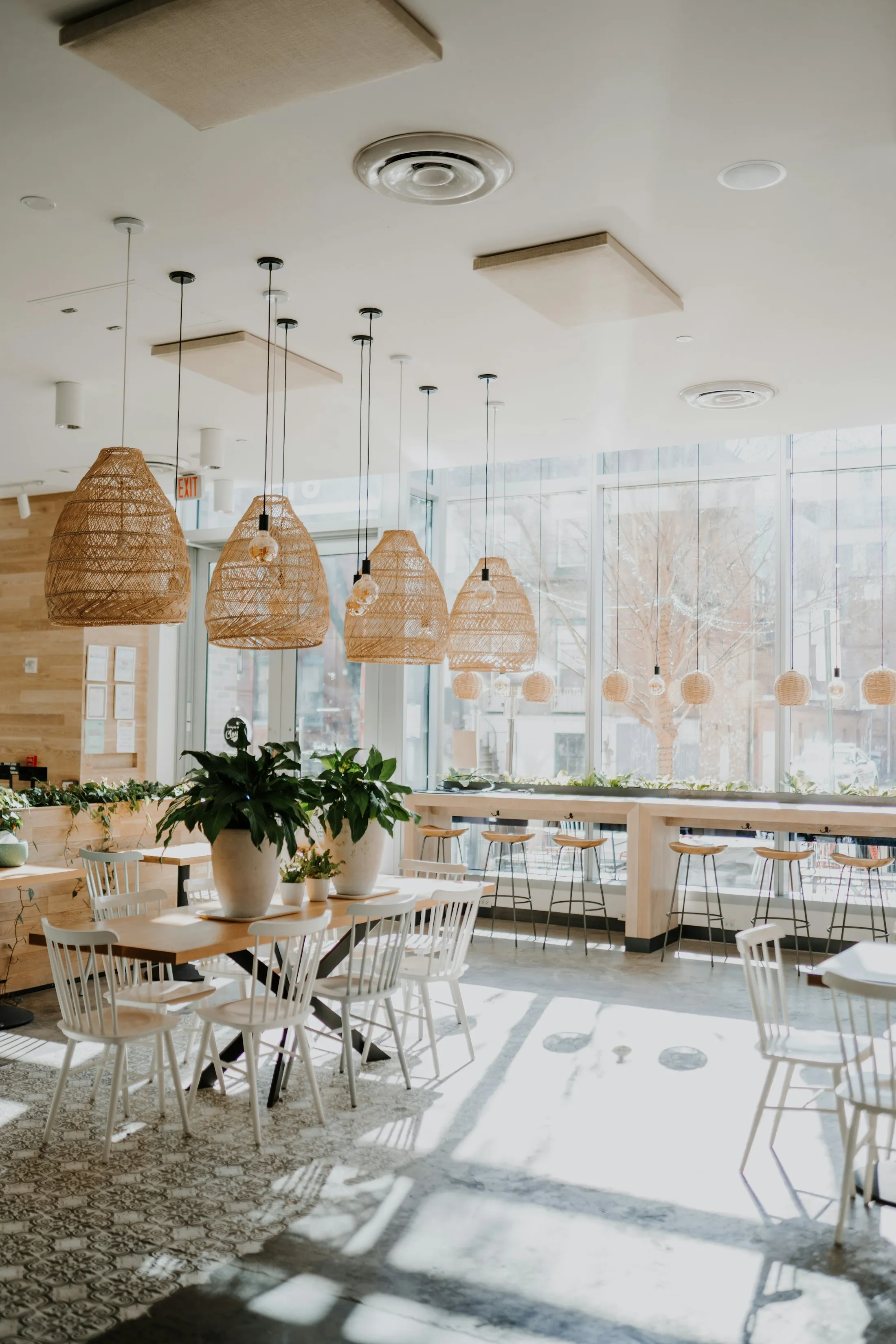 Restaurante luminoso con lámparas colgantes y difusores de aire en el techo