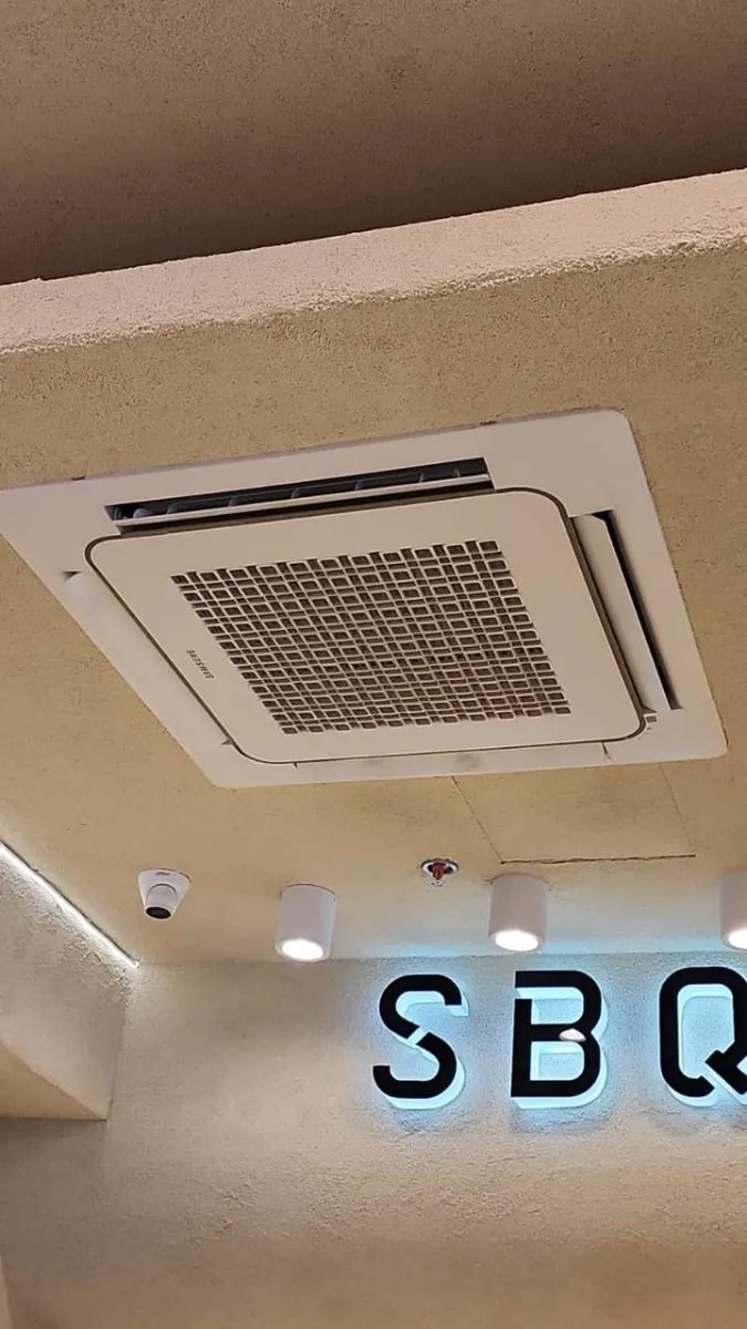 Tienda SBQ beige y dorada con un cassette de 4 vías centrado en el cielo texturizado